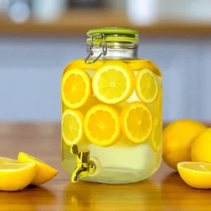 Dispensador para bebidas cuadrado de 4.1 litros con tapa cerámica y llave dorada lleno de limonada con rodajas de naranja