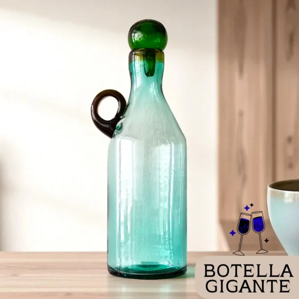 Botella de vidrio gigante estilo mexicano, colocada sobre una mesa de madera en un hogar moderno, con un logo que dice 'Botella Gigante'.