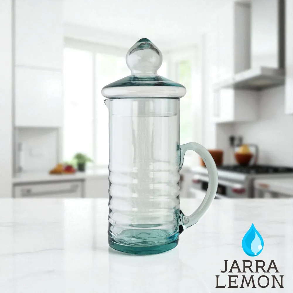 Jarra de vidrio para agua modelo Lemon con su tapa, en una cocina moderna y luminosa, con el logo del producto.