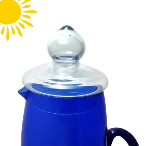 Primer plano de la tapa de vidrio transparente de la Jarra Tamy, mostrando su diseño y el contraste con el cuerpo de color azul cobalto.