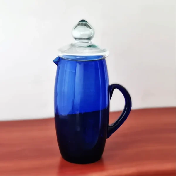 Jarra de vidrio Tamy de 2.1 litros en color azul cobalto, con su tapa, exhibida sobre una mesa de madera.